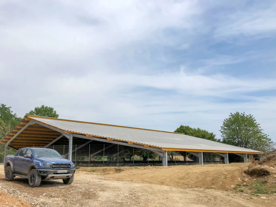 Façade extérieure d'entrepôt industriel avec deux portes sectionnelles blanches numérotées 3 et 4